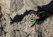 Climber scales a cliff.