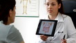 Doc explaining something in tablet to patient - tracking shot