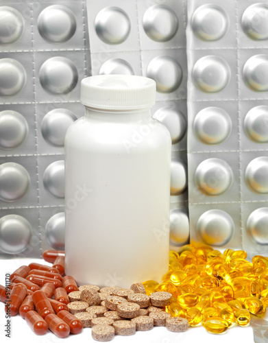 Photo: Yellow liquid capsules and silvery plates of medicines Yellow liquid capsules and silvery plates of medicines