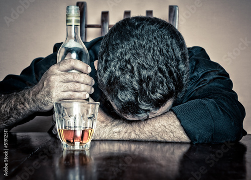 Photo: Grunge portrait of a drunk man sleeping with his head on a table Grunge portrait of a drunk man sleeping with his head on a table