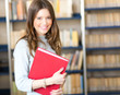 Young student holding a book in a library