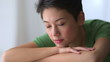 Serious Mixed race Asian woman with head in arms