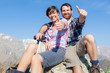 Young Couple with Thumbs Up at Top of Mountain