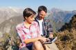 Couple with Digital Tablet at Top of Mountain