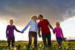 Happy family on meadow at sunset