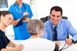 doctor checking senior patient's blood pressure