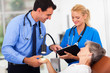 dermatologist and assistant recording senior patient's skin cond