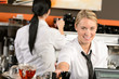 Foto: Young waitress cashier giving coffee in cafe Young waitress cashier giving coffee in cafe