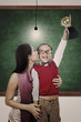 Photo: School champion holding trophy kiss by mum in class School champion holding trophy kiss by mum in class