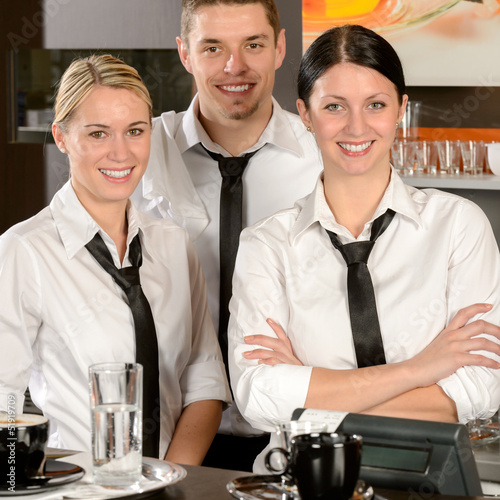 Photo: Three server posing in uniform in cafe Three server posing in uniform in cafe