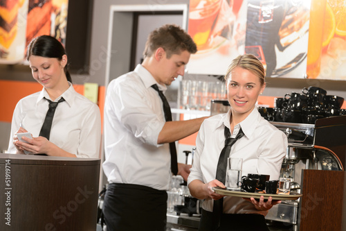 Photo: Confident waitresses and waiter working in bar Confident waitresses and waiter working in bar