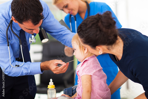 Photo: male doctor examining little girl male doctor examining little girl