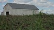 Barn in field on bright sunny day with blue skies