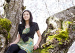 Photo: Young teen girl sitting on branches of flowering cherry tree Young teen girl sitting on branches of flowering cherry tree