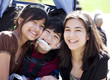 Disabled boy in wheelchair surrounded by big sisters, smiling