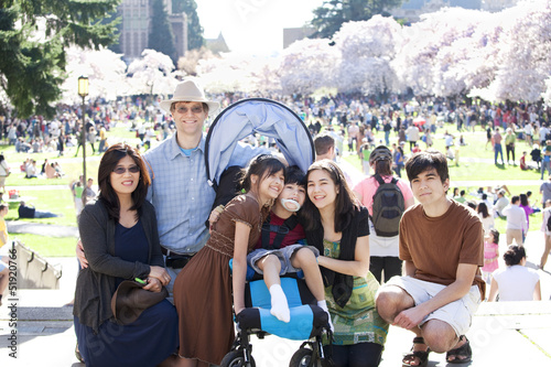 Photo: Large multiracial family in crowd with disabled child in wheelch Large multiracial family in crowd with disabled child in wheelch