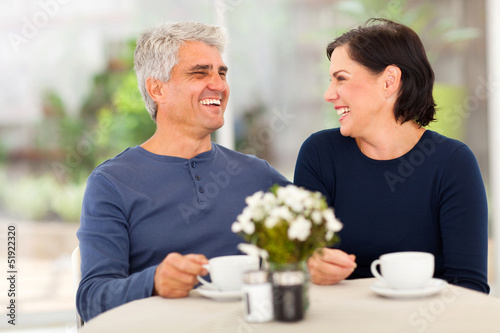 Photo: happy middle aged couple enjoying tea happy middle aged couple enjoying tea