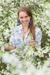 Smiling blonde in blooming garden