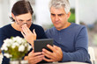 middle aged couple reading shocking news