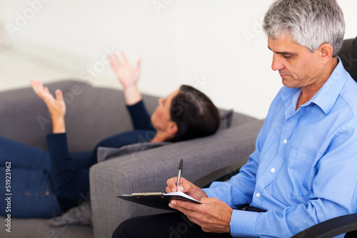 Photo: middle aged therapist consulting patient middle aged therapist consulting patient