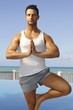 Photo: Athletic man practicing yoga outdoors Athletic man practicing yoga outdoors