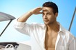 Foto: Young man on sailing boat at summertime Young man on sailing boat at summertime