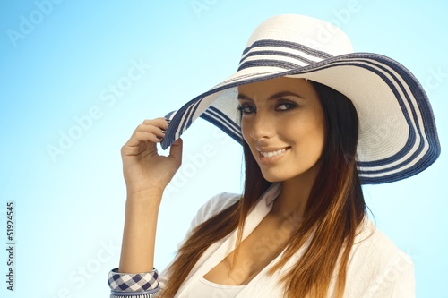 Photo: Closeup portrait of elegant woman in straw hat Closeup portrait of elegant woman in straw hat