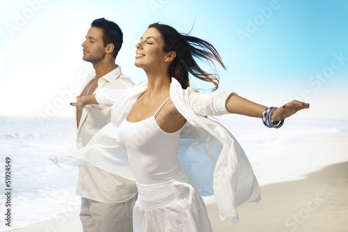 Photo: Young couple enjoying summer sun on the beach Young couple enjoying summer sun on the beach