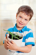 Photo: boy puts plant in pot boy puts plant in pot