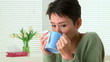 Woman sick with flu sneezing and drinking tea