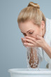 Foto: Young woman washing her face Young woman washing her face