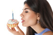 Beautiful young woman eating cupcake