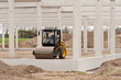 Rohbau einer Betonkonstruktion und eine Walze