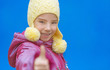 smiling girl in pink dress raises thumbs-up