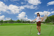 Photo: Young woman playing golf on a green golf course Young woman playing golf on a green golf course