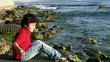 Little boy throwing stones into the sea
