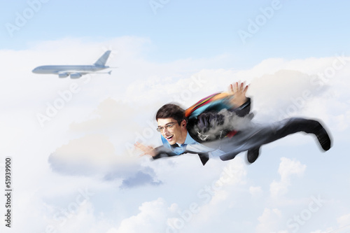 Photo: Young businessman flying with parachute on back Young businessman flying with parachute on back
