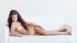 Video: Sexy Brunette Girl in Swimsuit is Lying on White Sofa Sexy Brunette Girl in Swimsuit is Lying on White Sofa
