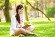 Foto: Woman reading book in park Woman reading book in park