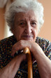 Photo: a senior woman leaning on wooden cane a senior woman leaning on wooden cane