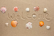 Word welcome written on the sand