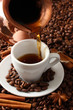 Cup and pot of coffee on coffee beans background