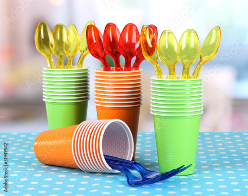Photo: Cups, spoons and forks, of different colors on bright Cups, spoons and forks, of different colors on bright