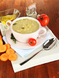 Nourishing soup in pink pan on wooden table close-up