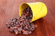 Overturned bucket with grains on wooden background