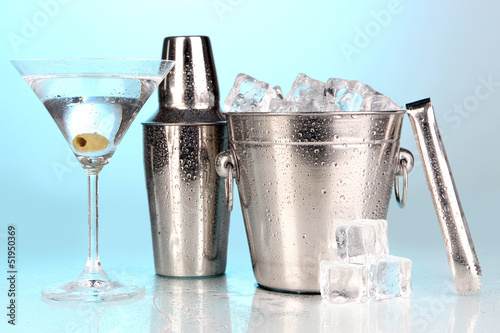 Photo: Metal ice bucket and shaker and cocktail on blue background Metal ice bucket and shaker and cocktail on blue background