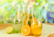 Orange and lemon lemonade in pitchers and glasses