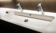 Modern white sink with two shining faucets, tap and soap