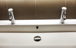 Modern kerrock sink with two shining faucet valves in bathroom