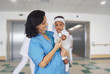 Photo: Brunette pediatrician at the hospital with a baby Brunette pediatrician at the hospital with a baby